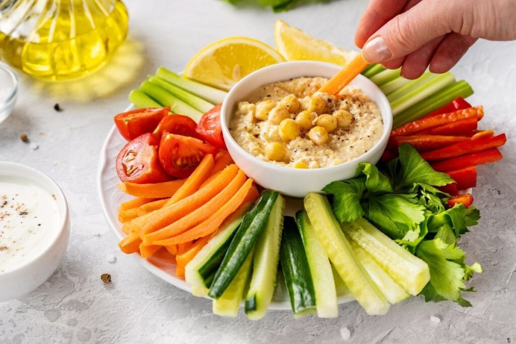 Para algo leve e crocante, invista em palitos de cenoura, pepino ou até mesmo pimentão (pimentão, com moderação, é claro)  acompanhados de hummus. Esse lanche oferece fibras, proteínas vegetais e vários nutrientes essenciais.